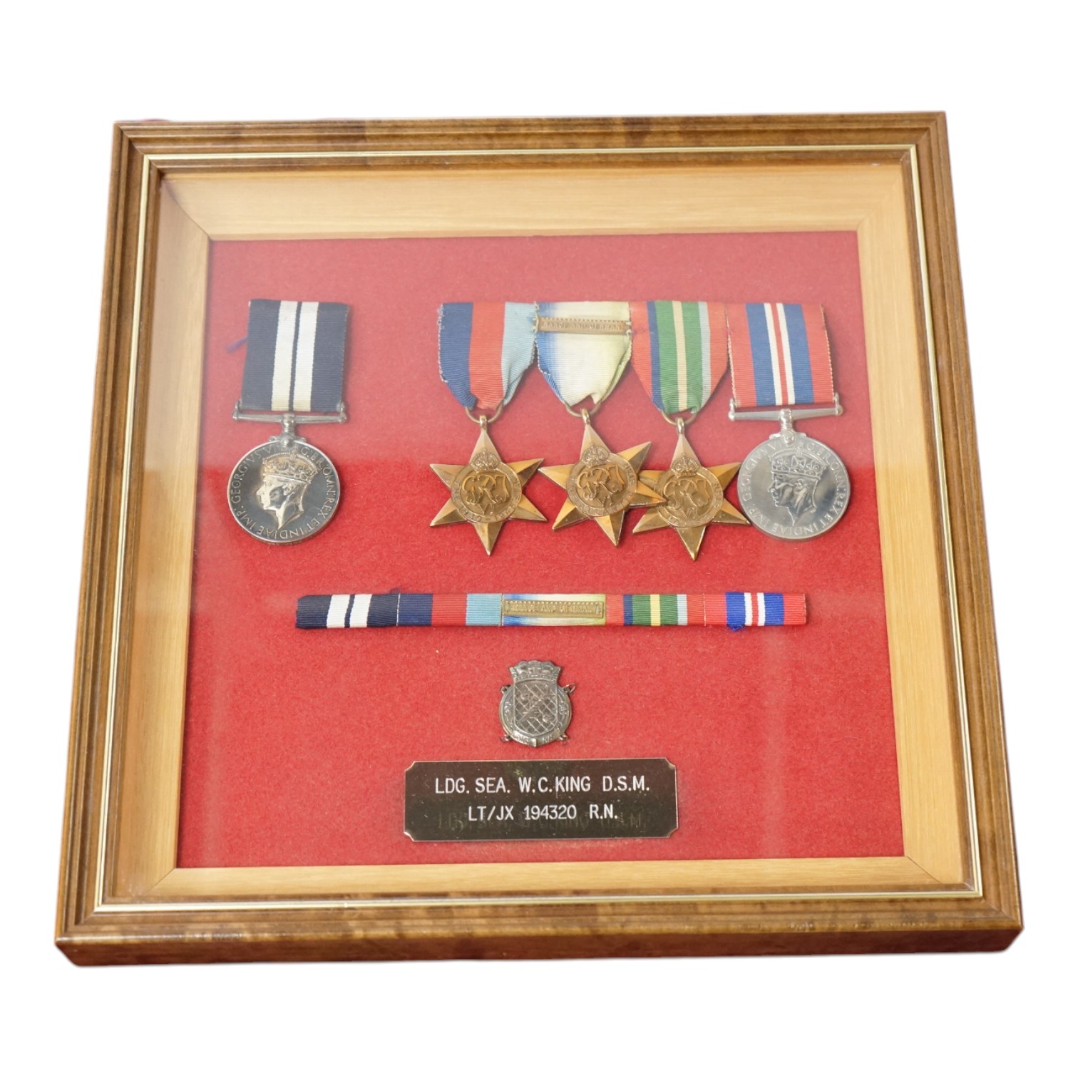 WWII Naval DSM group - framed, to Walter Charles King, comprising a replacement Distinguished Service Medal, the 1939-1945 Star, the Atlantic Star with clasp for France and Germany, the Pacific Star, and the 1939-1945 Me